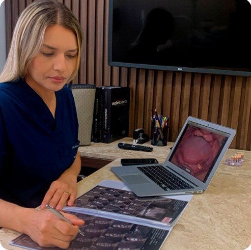 Dentista analisando exame de imagem para planejamento do implante