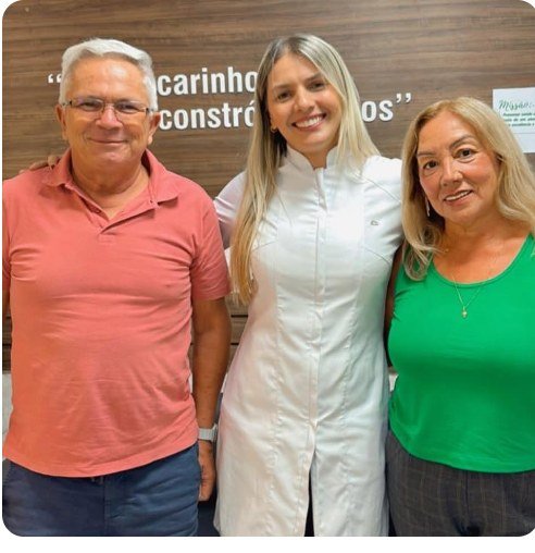 Casal de pacientes ao lado da dentista responsável